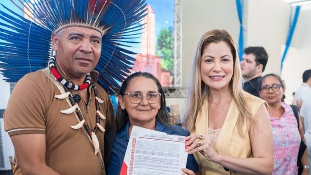 Cacique Sandro ao lado da deputada Danielle do Vale entrega escritura a moradora — Foto: Divulgação