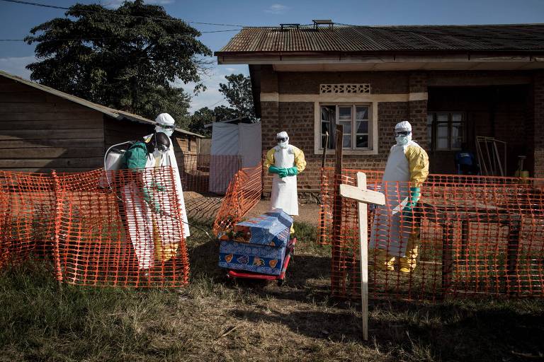Profissionais de saúde desinfetam o caixão de um paciente falecido com suspeita de ebola – Foto: John Wessels